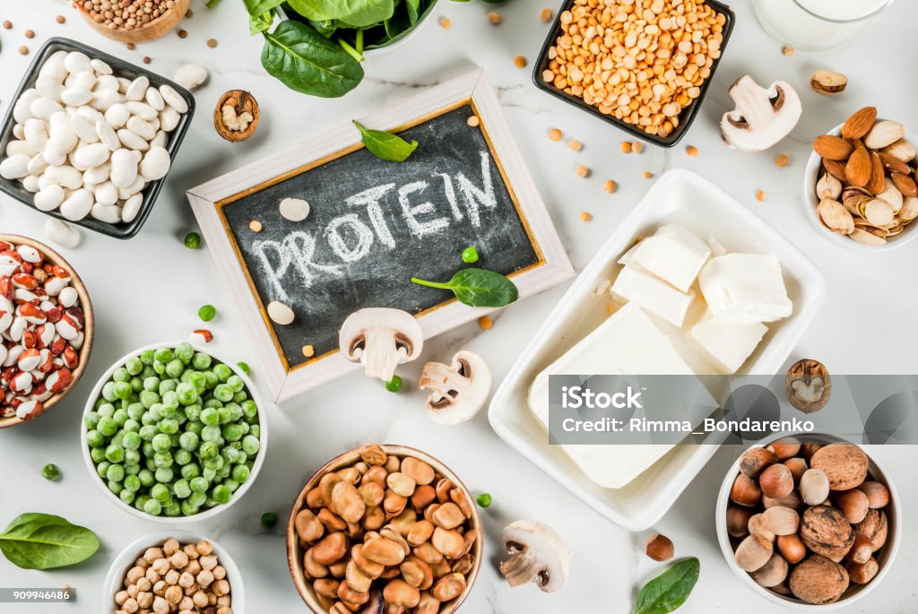 Vegan  protein sources Healthy diet vegan food, veggie protein sources: Tofu, vegan milk, beans, lentils, nuts, soy milk, spinach and seeds. Top view on white table. Protein Stock Photo
