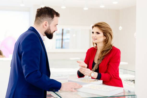 istock Young couple choosing wedding ring in jewelry store. 909946972