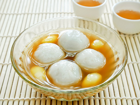 Sweet glutinous rice balls filled with black sesame seeds in sweet ginger syrup (Tang Yuan). Chinese dessert.