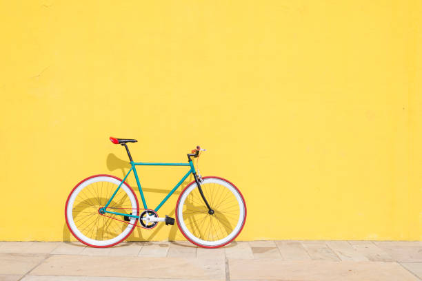 stały bieg roweru miejskiego na żółtej ścianie - bicycle cycling bicycle pedal part of zdjęcia i obrazy z banku zdjęć