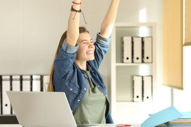 istock Satisfied intern raising arms at office 909948960