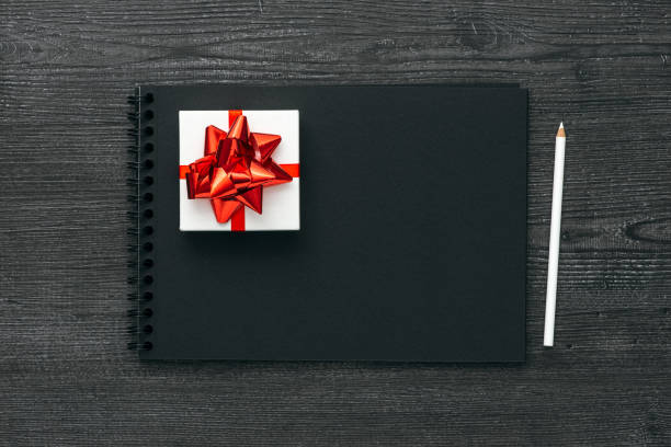 geschenk und notebook - tied knot pencil reminder ideas stock-fotos und bilder