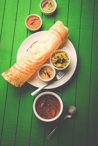 Masala dosa with chutney and sambar and potato sabzi. Dosa is a pancake from south India typically in Cone, triangle or roll shape, selective focus