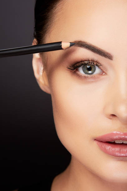istock Model painting eyebrows with black pencil 909964640