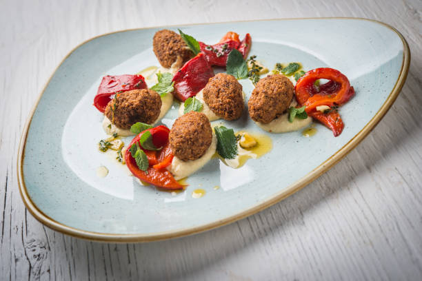 istock Hummus with falafel medallions in plate on white rustic wooden table 909970600