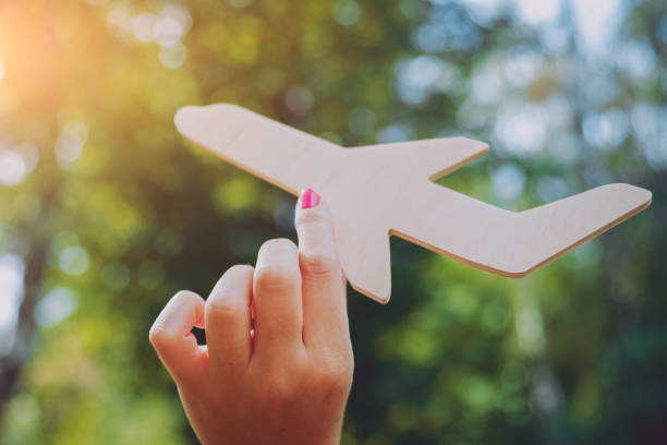 istock Hands with small wooden plane close up. Advertising concept. Outdoors. Summertime. 909976254