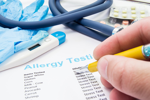 Doctor controles análisis de alergia del paciente cerca de estetoscopio y termómetro. Escena del trabajo o de actividades profesionales del médico general, alergista, pediatra o terapeuta en el tratamiento de la alergia photo