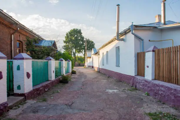 Narrow stone streets with green fences and white pillars and walls in the small historic old town of Ovruch, Zhytomyr region, Ukraine, the former capital of ancients Drevlians. Sunrise photo