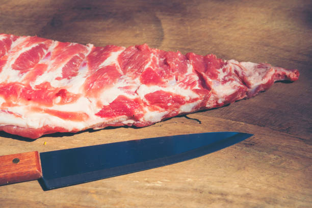 Raw ribs with a rosemary and vegetables. on crumpled paper