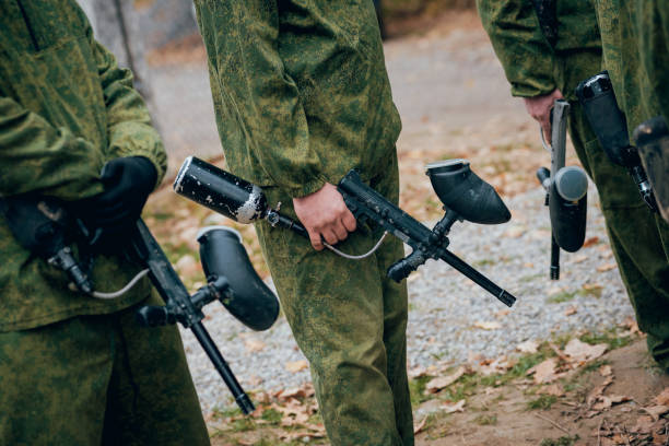 istock Men with guns playing at paintball. Outdoors 909985758