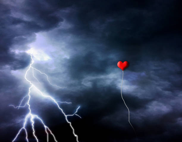 istock Red balloon floating in a stormy sky and lightning 909986296