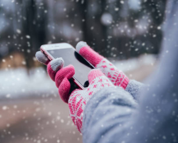 istock Woman using smartphone in winter with gloves for touch screens 909986750