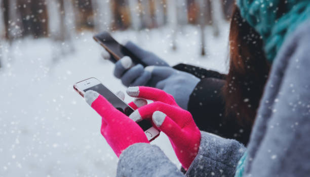 istock Couple using smartphone in winter with gloves for touch screens 909986892