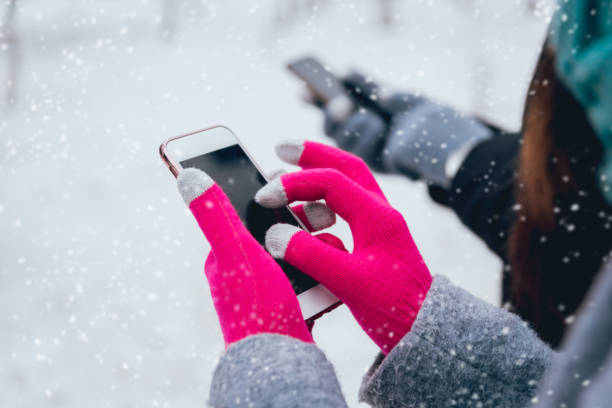 istock Couple using smartphone in winter with gloves for touch screens 909987002