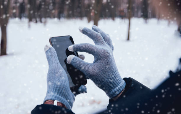 istock Man using smartphone in winter with gloves for touch screens 909987212