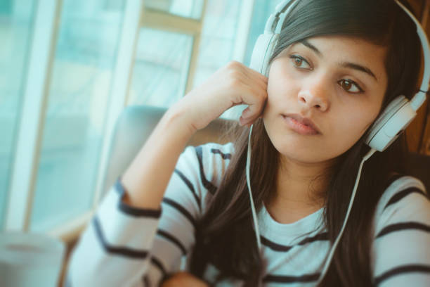 samotna młoda kobieta słucha podcast. - blank expression audio zdjęcia i obrazy z banku zdjęć