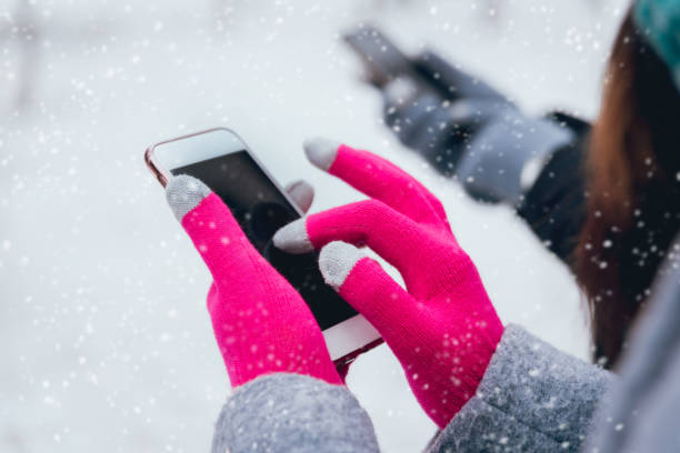 istock Couple using smartphone in winter with gloves for touch screens 909987374