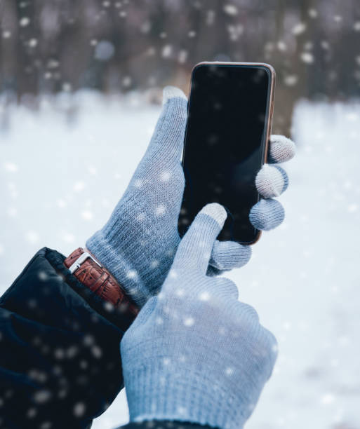 istock Man using smartphone in winter with gloves for touch screens 909987500
