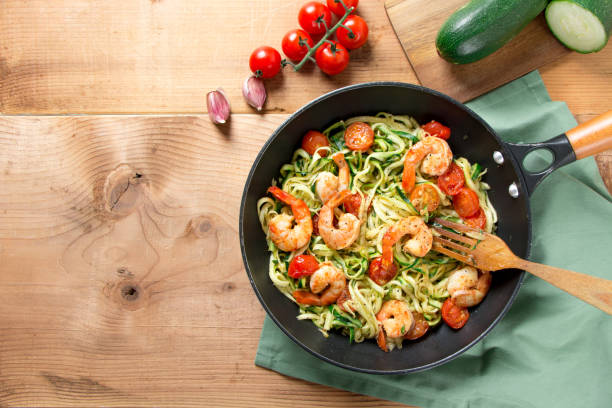 tallarines de calabacín con tomate cherry y gambas en una sartén - saute fotografías e imágenes de stock