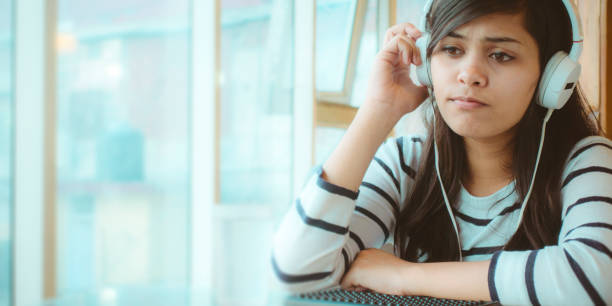 istock Single young woman listening podcast. 909988528