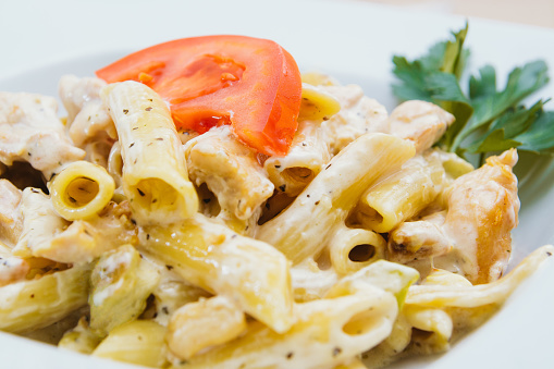 Traditional italian pasta (macaroni) with cream cheese and tomato, homemade healthy food on the table