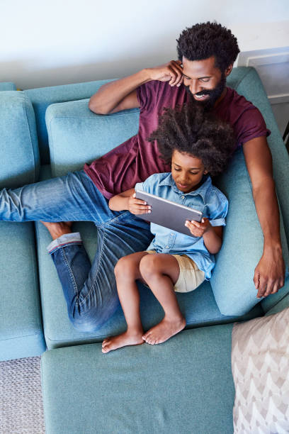 デジタル タブレットを使用するあなたのターンのように見える - digital tablet family father offspring ストックフォトと画像