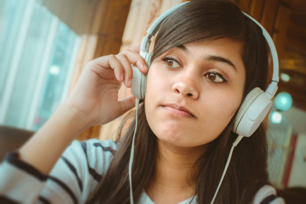 istock Single young woman listening podcast. 909998006