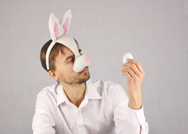 man in the mask Easter Bunny looking at the egg
