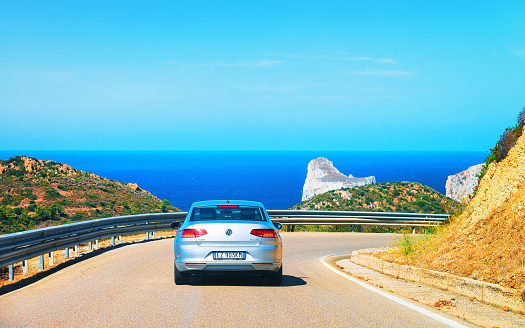 Nebida, Italy - September 13, 2017: Car on the road at Porto Corallo in Nebida, with the Mediterranean Sea, Carbonia-Iglesias, Sardinia, Italy