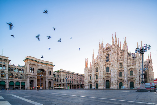 Galleeria Vittorio Emenuele and Milan Cathedral square with flying pegion in the morning