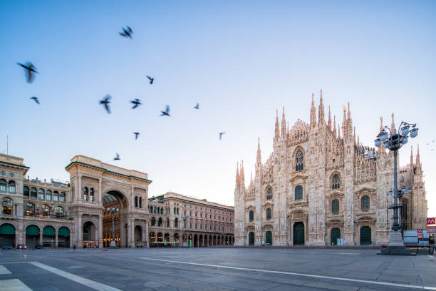 the Piazza del Duomo at dawn Galleeria Vittorio Emenuele and Milan Cathedral square with flying pegion in the morning cathedrals stock pictures, royalty-free photos & images