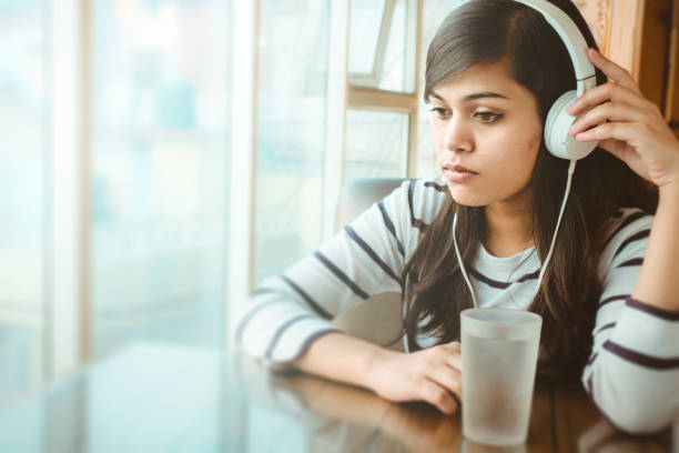 istock Single young woman listening podcast. 910006378