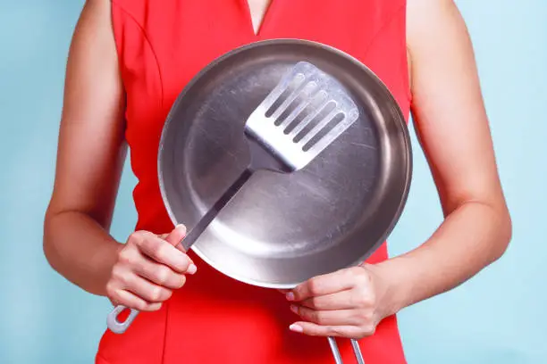 Concept housewife cooks food using kitchen utensils.