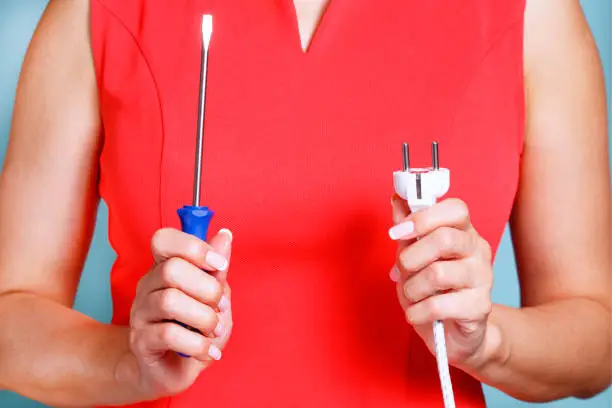 Housewife repairs an electrical device at home. FAQ how to make yourself.