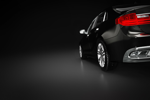 Modern black metallic sedan car in spotlight. Generic desing, brandless. 3D rendering.