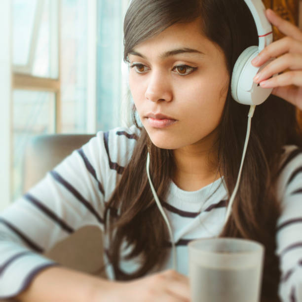 istock Single young woman listening podcast. 910009862
