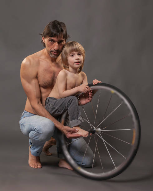 vater und sohn in jeans - child lifestyles isolated blue stock-fotos und bilder