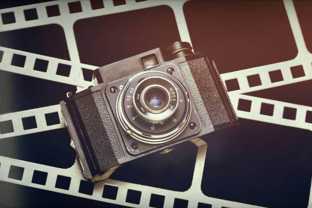 istock Old retro rangefinder camera on background of film perforation 910011654