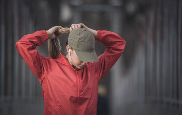 Hairstyle for practice Young strong woman tying her hair in ponytail and getting ready for practice woman tying hair in ponytail getting ready for exercising stock pictures, royalty-free photos & images