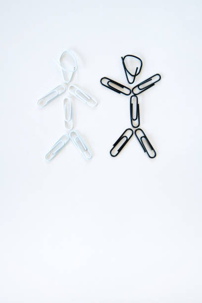 istock Two people from multi ethnic group, one happy, one unhappy - concept with paper clip stick figures 910015928
