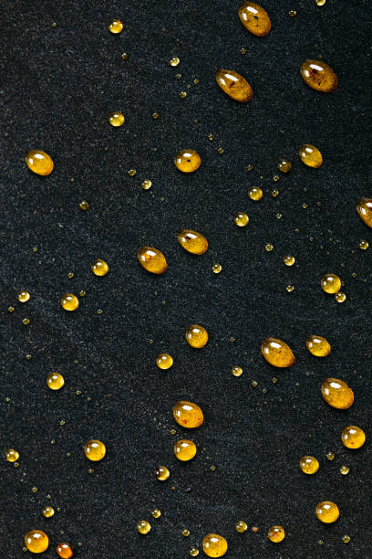 istock Abstract black background with golden glitter dots. Caramel on frying pan 910016316