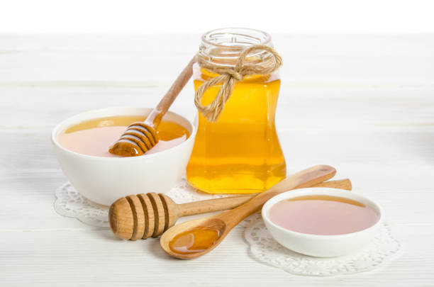 istock honey in a spoon, a jar and a bowl on wooden table 910016442