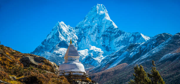 Traditional white-washed Buddhist stupa and mani stones high in the thin mountain air above the Khumbu valley overlooked by Ama Dablam (6812m) deep in the remote Himalayan wilderness of the Sagarmatha National Park, a UNESCO World Heritage Site, Nepal.