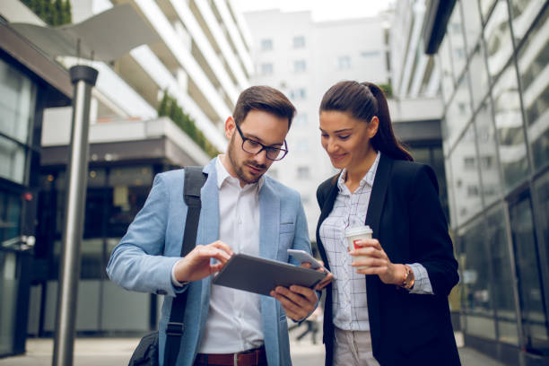 istock Business team discussing business project using digital tablet outdoors 910022140