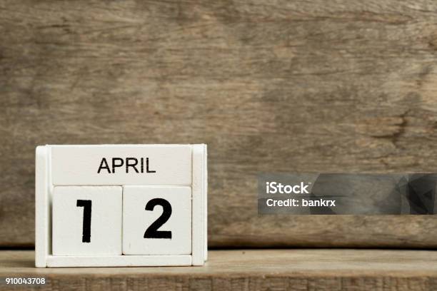 White Block Calendar Present Date 12 And Month April On Wood Background Stock Photo - Download Image Now