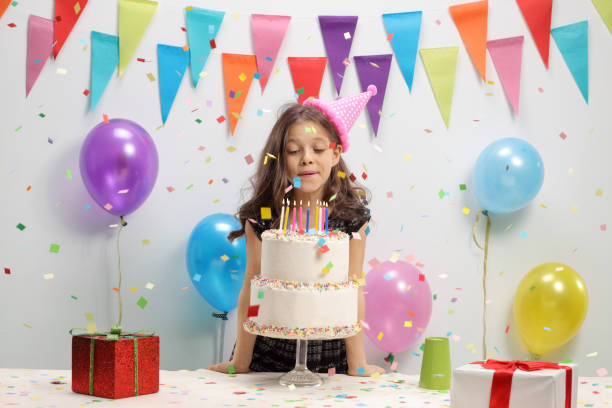Little girl blowing candles on a birthday cake Little girl blowing candles on a birthday cake birthday present photos stock pictures, royalty-free photos & images