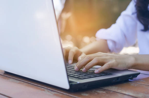 istock beautiful asian woman hands using laptop typing on keyboard working or searching web browser internet online in social net work for some data at outdoor with sunlight. 910049378