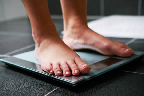 istock Female bare feet on the digital scale 910049854