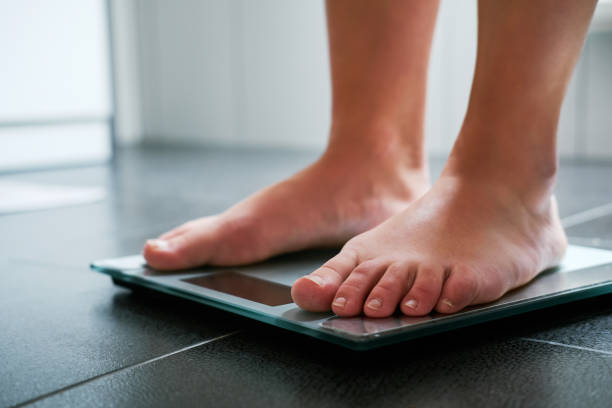 istock Female bare feet on the digital scale 910049858