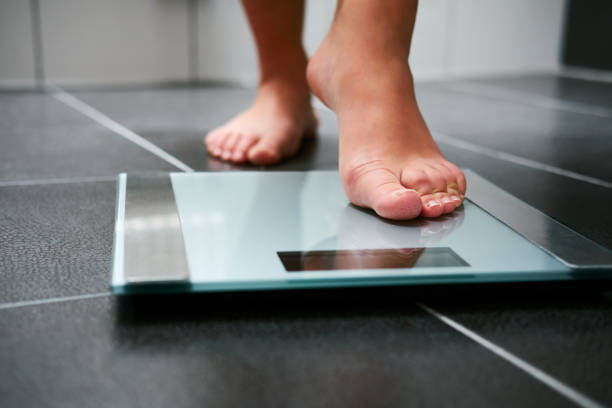 female bare feet with weight scale - anorexia imagens e fotografias de stock